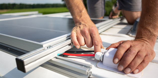 Homme qui installe des câbles de panneau solaire