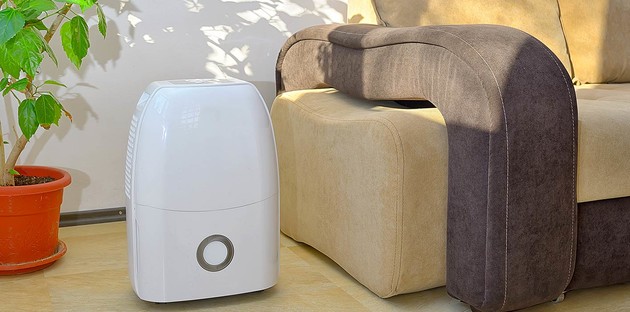 climatiseur mobile réversible à côté d'un canapé