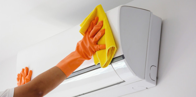 Nettoyage d’une unité intérieure de climatisation avec chiffon microfibre pour éliminer poussières et impuretés.