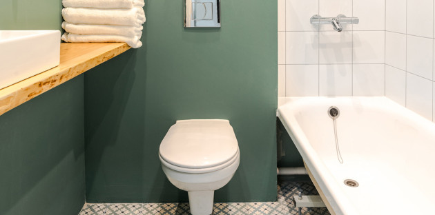 Petite salle de bains verte avec baignoire et WC