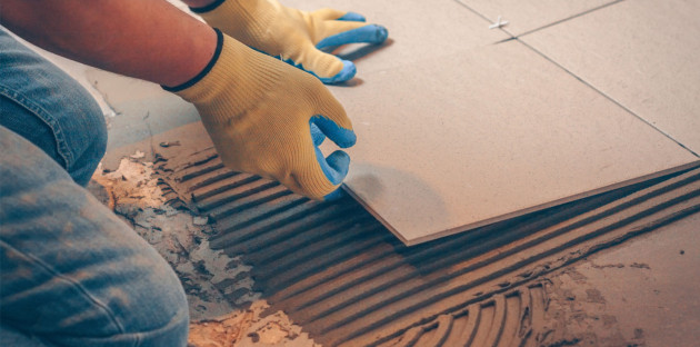 Homme qui pose des carreaux de carrelage extra fins