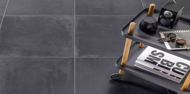 Carrelage noir grand format dans une cuisine contemporaine, finition mate effet béton, illustrant une tendance durable et élégante pour les cuisines en 2026.