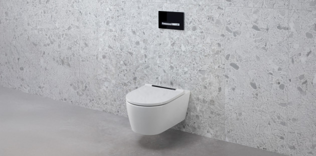 WC suspendu blanc moderne sur un mur en carrelage effet terrazzo gris clair dans une toilette design.