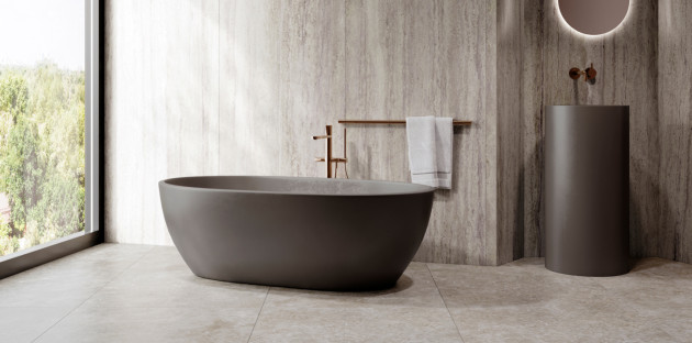 Salle de bains moderne avec baignoire îlot et carrelage travertin gris, pour une ambiance naturelle et contemporaine.