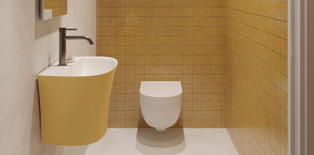 Petit espace WC avec toilette suspendue blanche, lave-mains jaune et carrelage mural ocre.