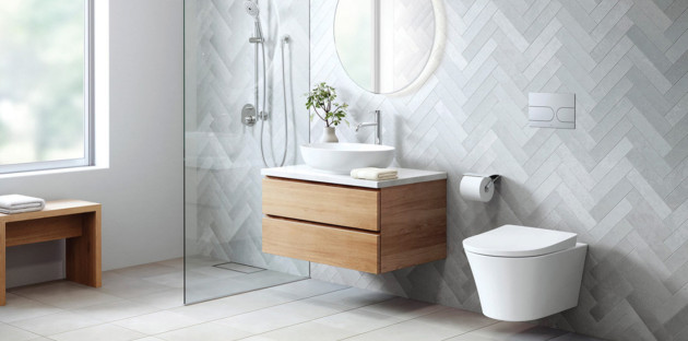 Salle de bains lumineuse avec WC suspendu blanc, meuble vasque en bois et carrelage mural en chevrons.