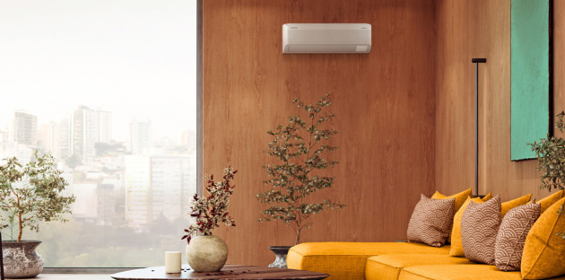 Salon moderne avec climatisation réversible murale installée sur un mur en bois au-dessus d’un canapé jaune design.