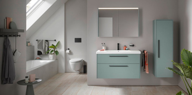 Meuble vasque suspendu vert avec deux tiroirs, miroir lumineux et colonne de rangement assortie.