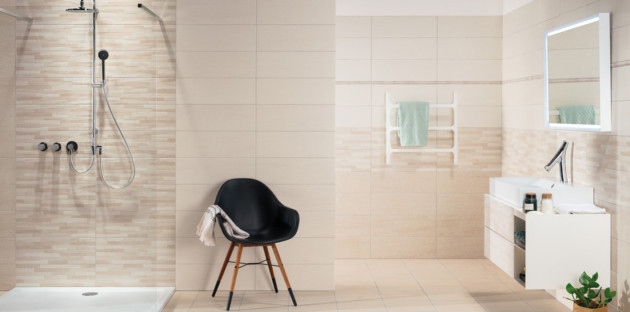 Salle de bains beige avec frise décorative.