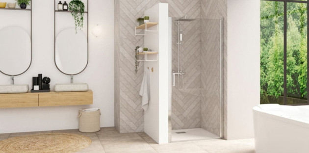 Salle de bains lumineuse avec douche équipée d’une paroi vitrée pivotante et d’un receveur blanc.