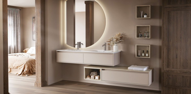 Meuble double vasque suspendu avec miroir rond rétroéclairé dans une salle de bains aux tons beige et bois.