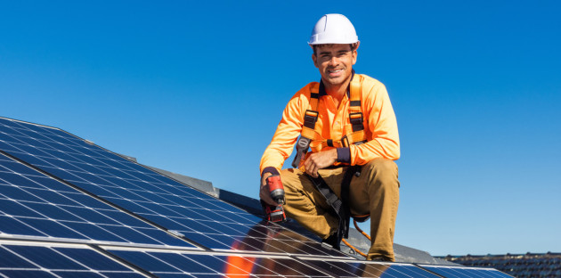 Ouvrier souriant sur un panneau photovoltaïque