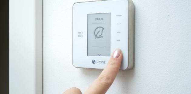 Femme qui utilise un thermostat d'ambiance