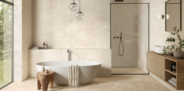 Salle de bains minimaliste avec baignoire îlot, douche à l’italienne et faïence beige grand format.