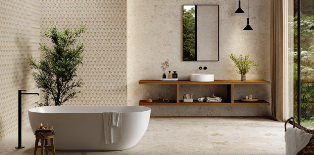 Salle de bains zen avec baignoire îlot, meuble suspendu en bois et carrelage texturé aux tons beiges naturels.