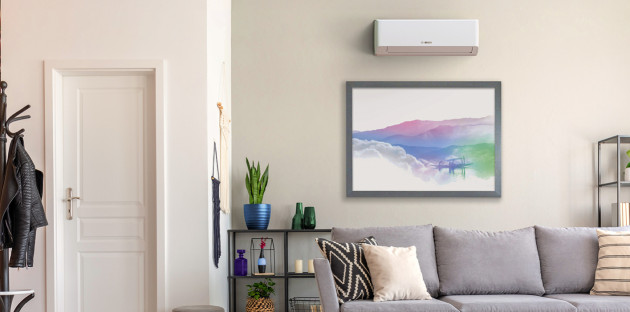 Salon moderne avec climatisation murale installée au-dessus du canapé pour un confort thermique optimal.