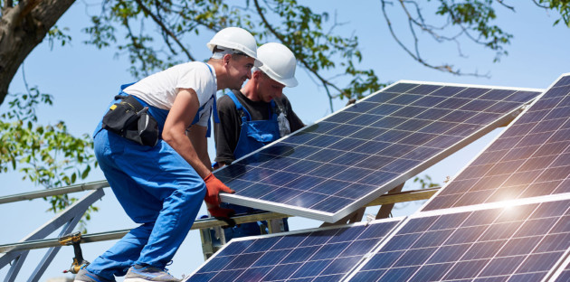 Deux experts en train de poser deux panneaux solaires