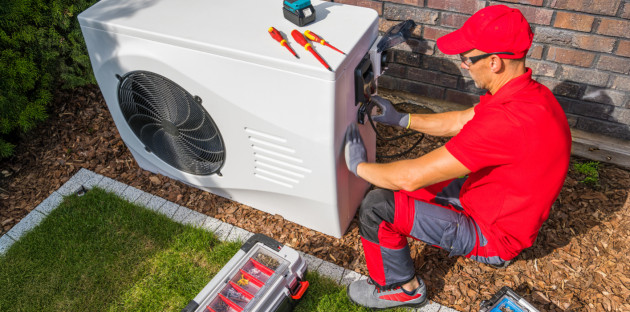 Technicien installant une pompe à chaleur extérieure.