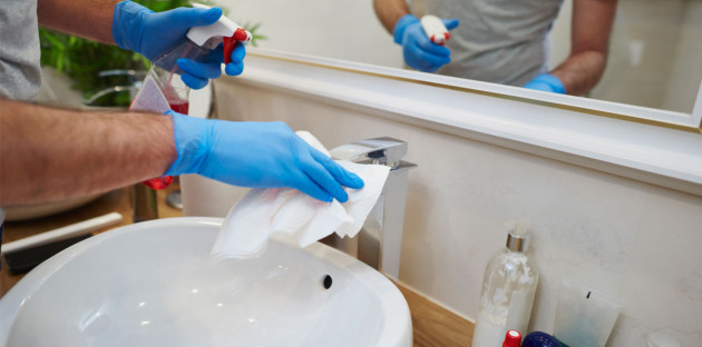 Nettoyage minutieux d’un robinet de salle de bains avec produit désinfectant et chiffon.