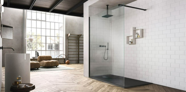salle de bain moderne et spacieuse avec une grande douche à l'italienne à paroi en verre strié avec un mur en carrelage et un sol en parquet