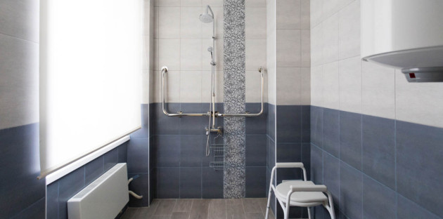 Salle de bains sécurisée avec douche senior équipée de barres d’appui et siège, idéale pour remplacer une baignoire.