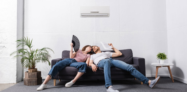 Couple qui a chaud mais qui profite de l'air frais de leur climatisation