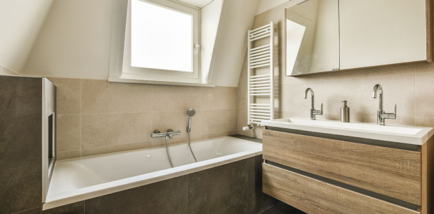 Salle de bains sous combles avec baignoire et meuble double vasque.