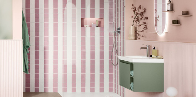Salle de bains colorée avec douche à l’italienne habillée de carreaux roses et blancs et meuble vasque vert sauge suspendu.