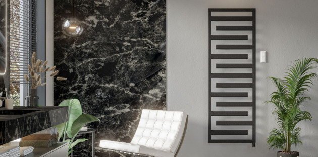 Sèche-serviettes design noir intégré dans une salle de bains contemporaine avec revêtement effet marbre noir et mobilier haut de gamme.