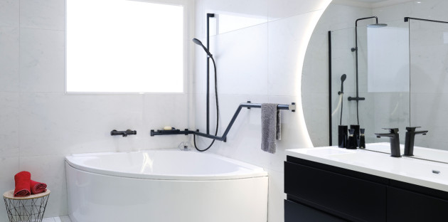 Salle de bains moderne avec baignoire d’angle, robinetterie noire