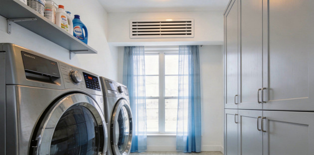 Buanderie avec lave-linge, sèche-linge et grille de ventilation