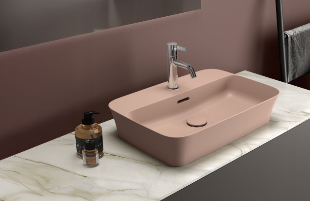 Vasque rectangulaire rose poudré avec mitigeur chromé sur plan effet marbre.