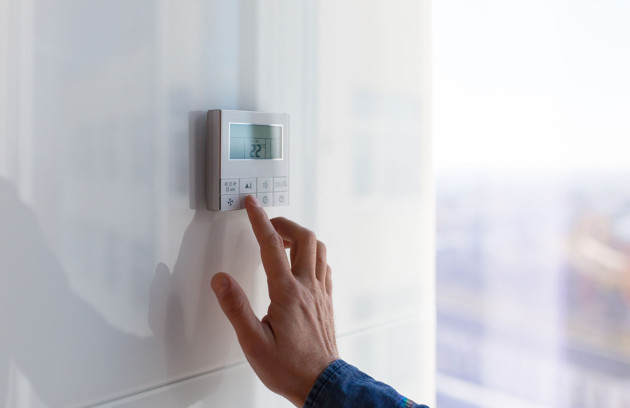 Réglage d'un thermostat mural d’une climatisation à 22 °C, illustration d’un bon réglage de clim pour optimiser le confort thermique et réduire la consommation d’énergie dans le logement.