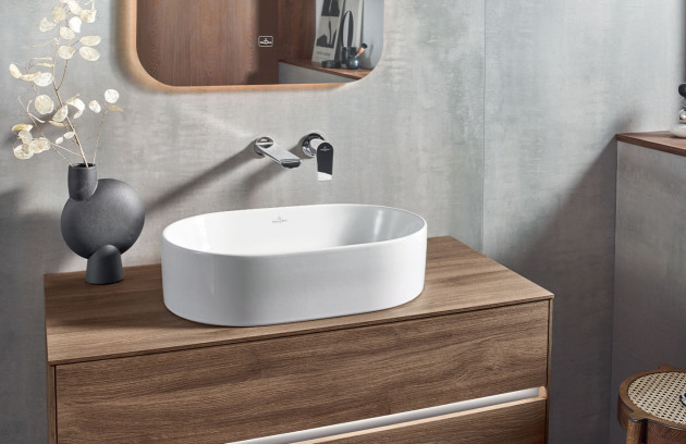 Vasque à poser ovale sur meuble en bois avec robinetterie murale, déco contemporaine.