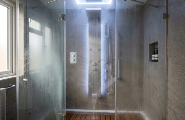 Douche moderne équipée d’une colonne hydromassante avec plusieurs jets d’eau.