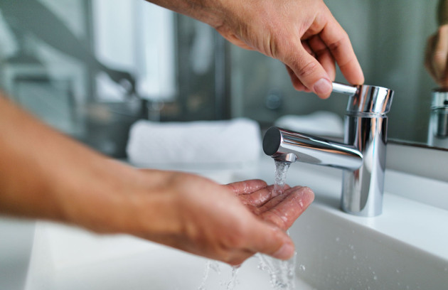 Robinet de salle de bains avec eau chaude en cours d’écoulement, illustrant l’usage d’un chauffe-eau instantané pour la production d’eau chaude sanitaire à la demande au lavabo.