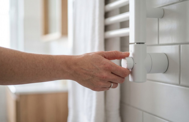 Réglage du thermostat d'un radiateur sèche-serviettes blanc.