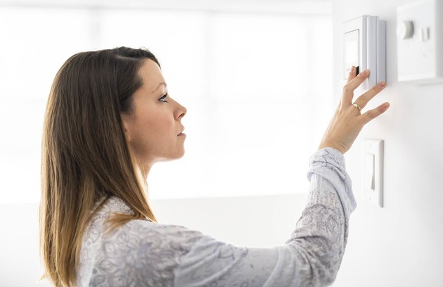 jeune femme qui utilise un thermostat