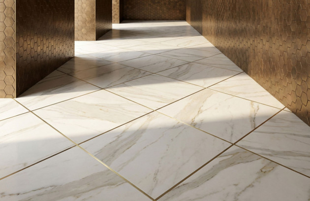 Carrelage grand format effet marbre au sol avec joints fins et faïence murale hexagonale effet métal, illustrant les formats et finitions de carrelage pour un intérieur contemporain.