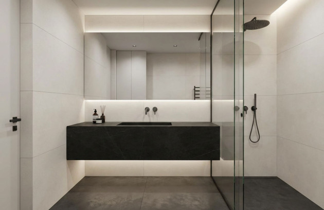 Salle de bains minimaliste avec carrelage grand format beige sur murs et sol, douche à l’italienne vitrée et meuble vasque suspendu noir, illustrant le choix du carrelage en ambiance contemporaine.