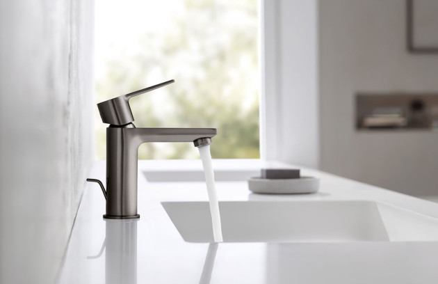 Mitigeur noir sur vasque blanche, salle de bains minimaliste et claire.