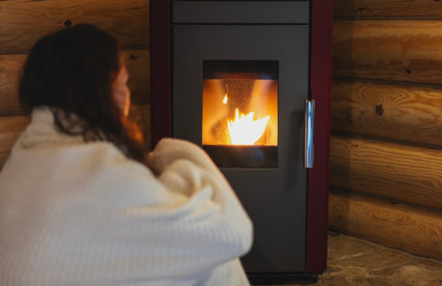 Personne profitant de la chaleur d’un poêle à granulés en ambiance cosy