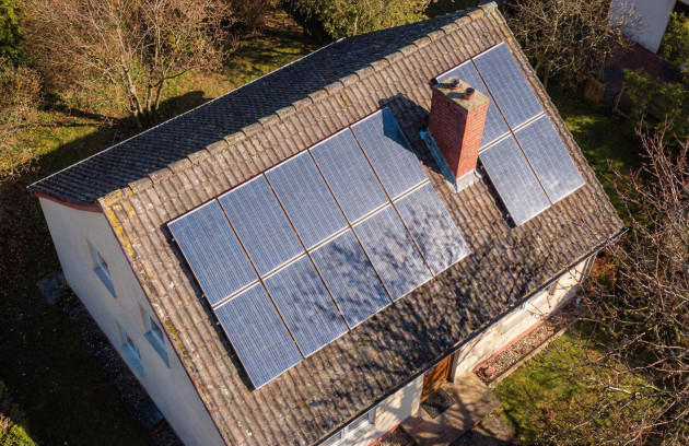 Vue aérienne d’une maison équipée de panneaux solaires photovoltaïques installés sur une toiture inclinée, illustrant une installation solaire résidentielle produisant de l’électricité renouvelable.