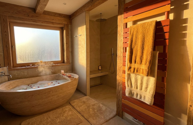 Salle de bains chaleureuse avec sèche-serviettes design en bois, serviettes chauffées et ambiance spa pour un confort thermique optimal.