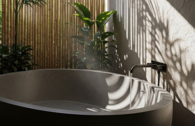 Robinet mural noir remplissant une baignoire, ambiance minérale avec plantes.