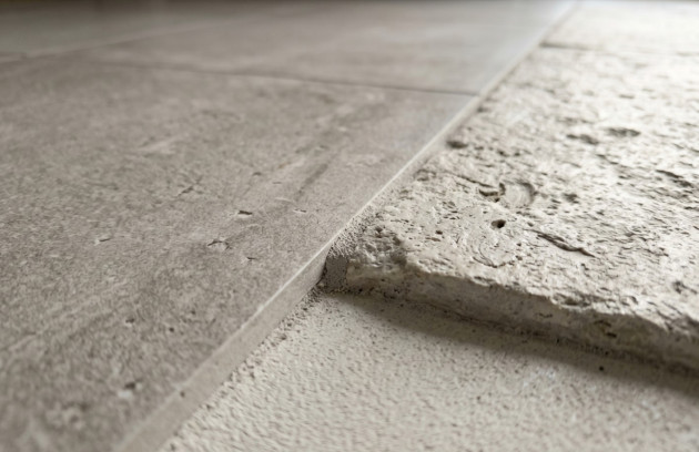 Différence d’épaisseur entre un carrelage posé et une dalle en cours de rénovation.