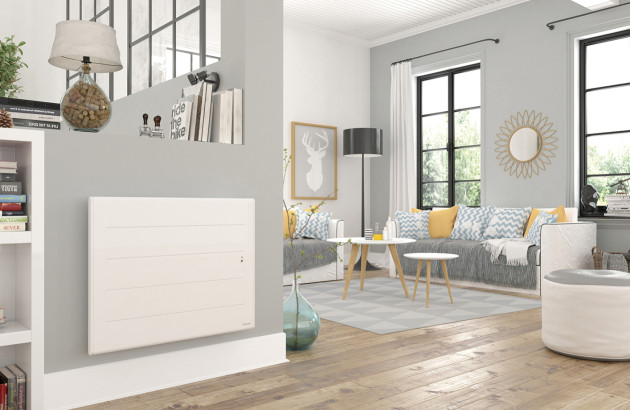 Radiateur rayonnant mural blanc dans un salon, panneau rayonnant électrique diffusant une chaleur infrarouge douce et rapide.