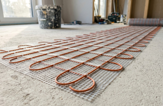 Natte chauffante électrique prête à être installée sur un sol en rénovation.