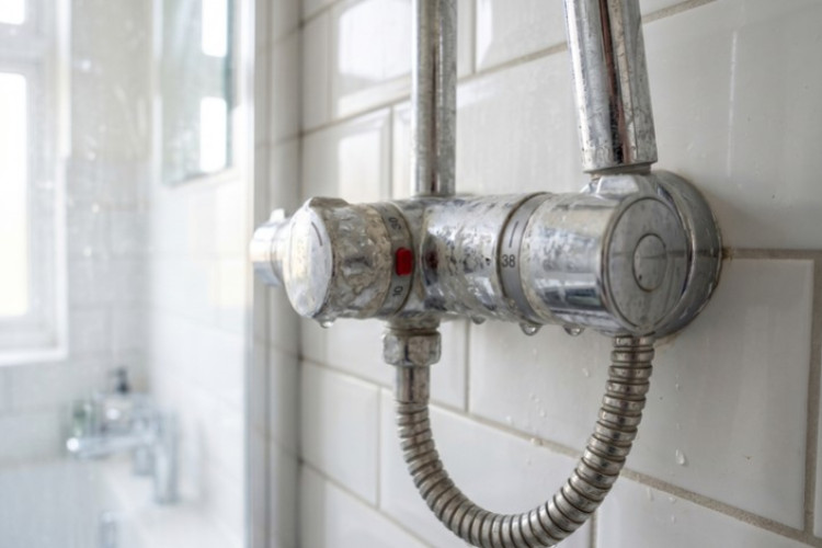 Mitigeur thermostatique de douche entartré, illustrant les effets d’une eau calcaire sur la robinetterie.