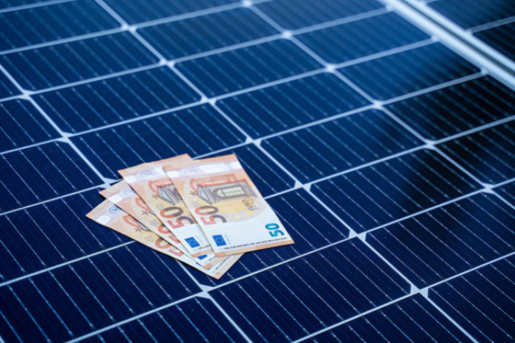 4 billets de 50 euros sur un panneau solaire